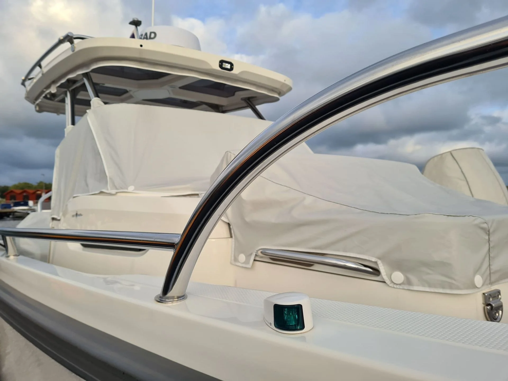 Boat windshield and canvas canopy detail with navigation equipment visible on console.