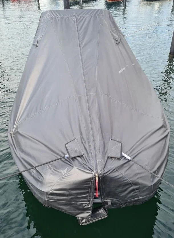 Boat cover protecting moored vessel in Cape Coral canal waters with residential docks visible.