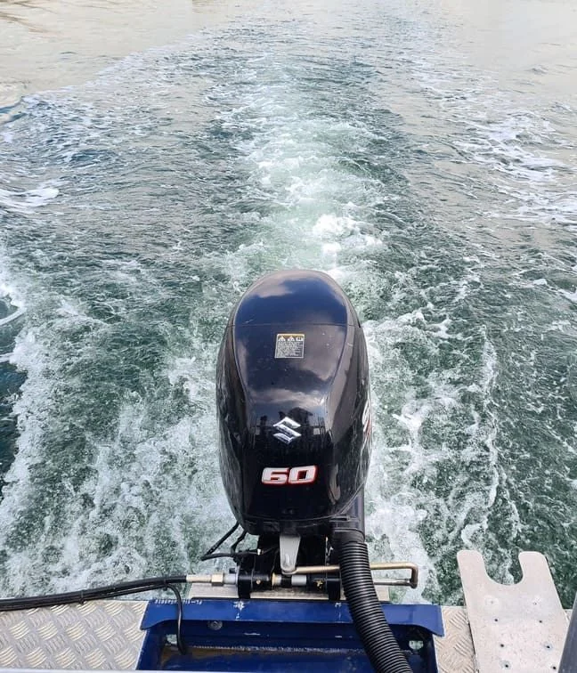 Outboard motor mounted on recreational powerboat underway in open water, Cape Coral.