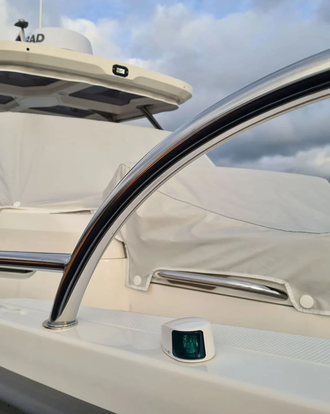 Close-up of boat windshield frame and navigation light detail on white hull.