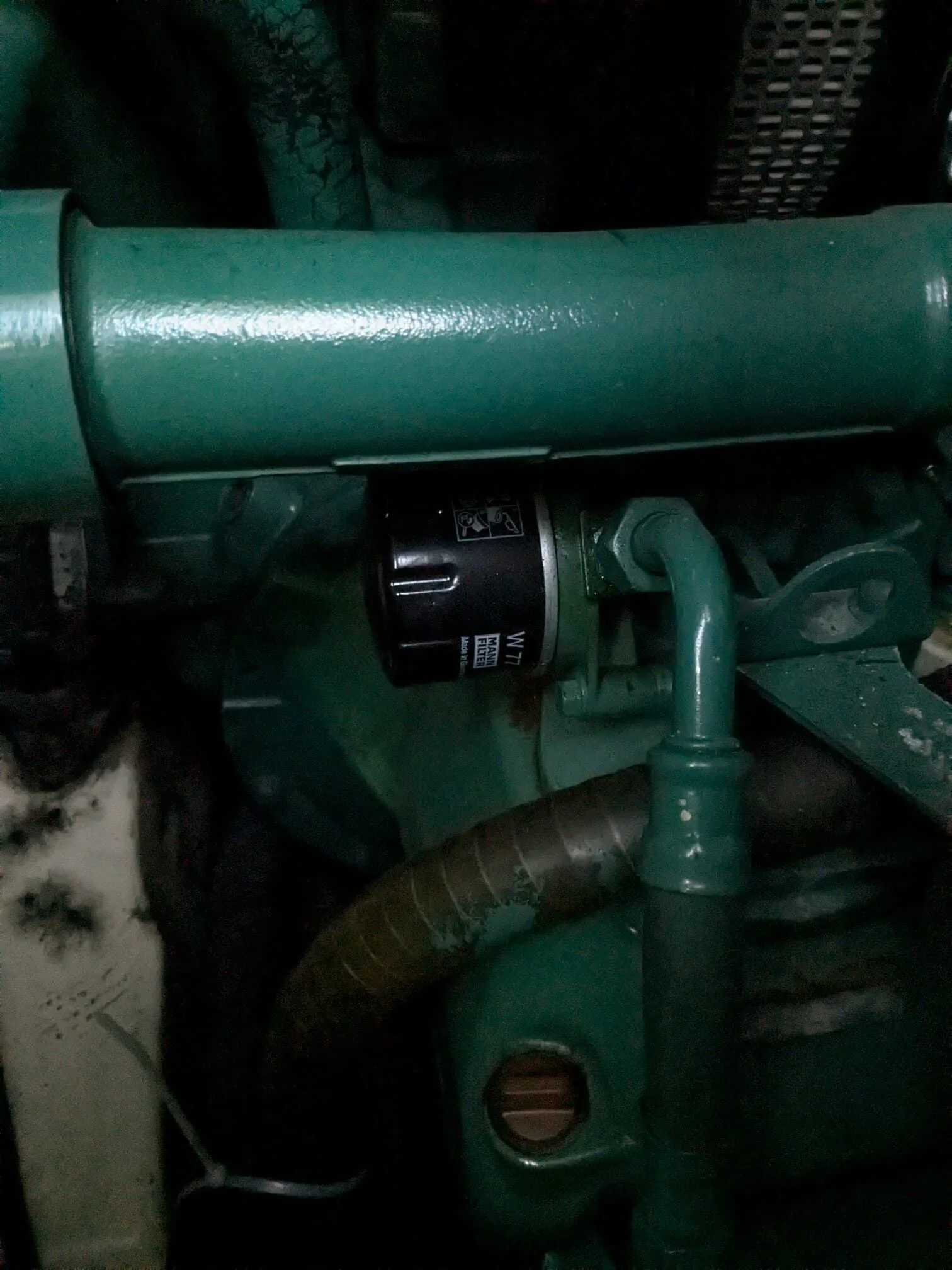 Close-up of marine engine component with green painted metal housing and black motor assembly.