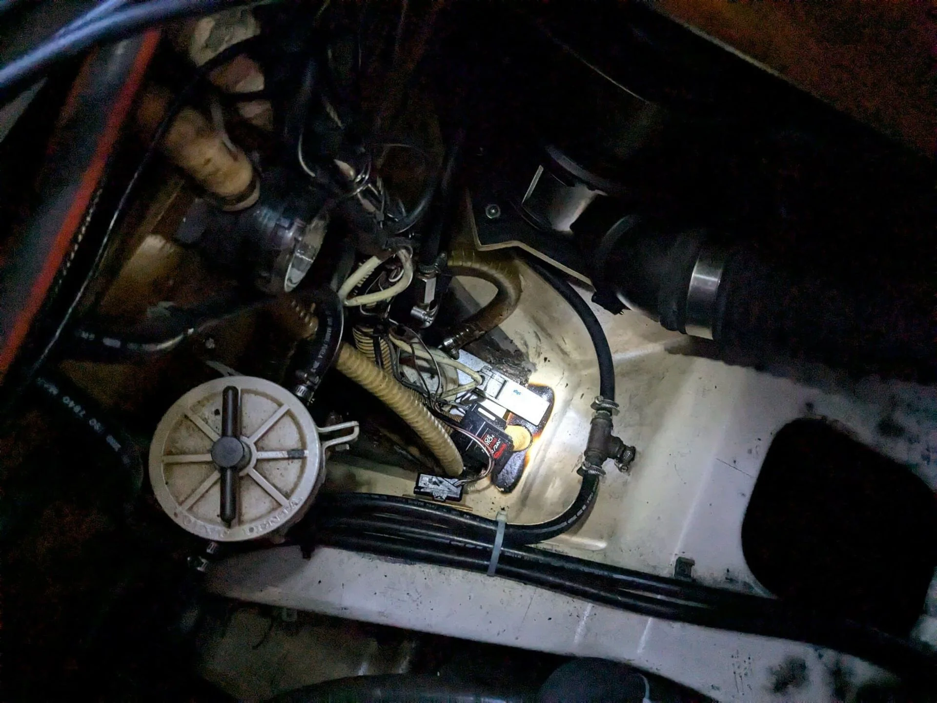 Marine electrical components and wiring harness inside boat engine compartment during service.