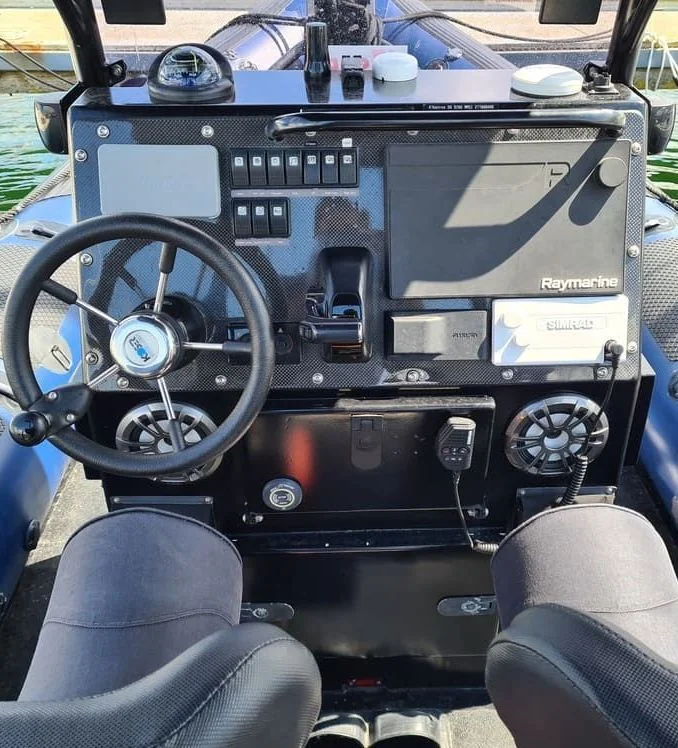 Boat console dashboard with navigation electronics and steering wheel docked in Cape Coral.