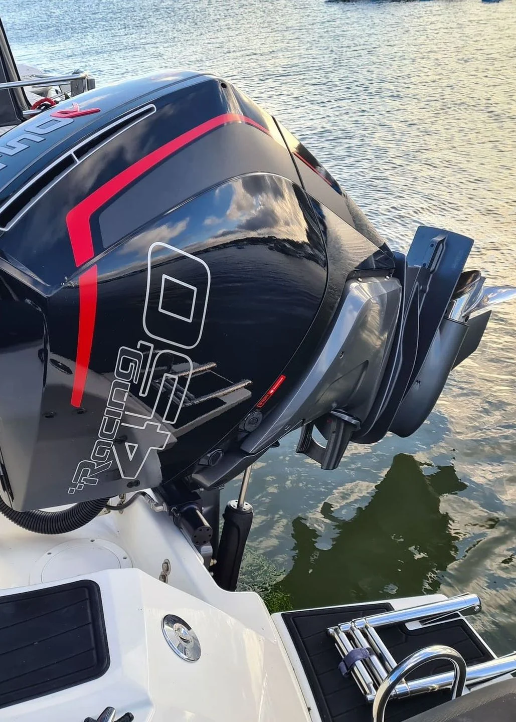 High-performance outboard motor mounted on recreational powerboat docked in shallow Florida canal water.