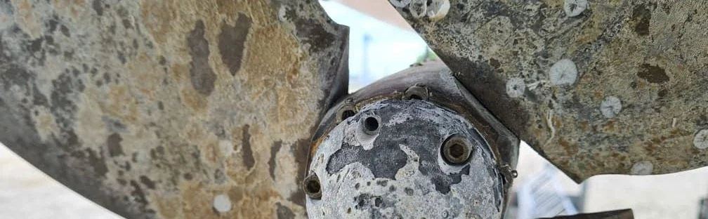 Corroded marine propeller hub showing salt water damage and barnacle growth.